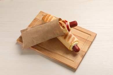 Photo of Delicious french hot dogs on white wooden table