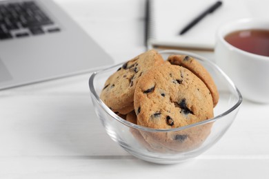 Photo of Chocolate chip cookies on white wooden table in office, closeup