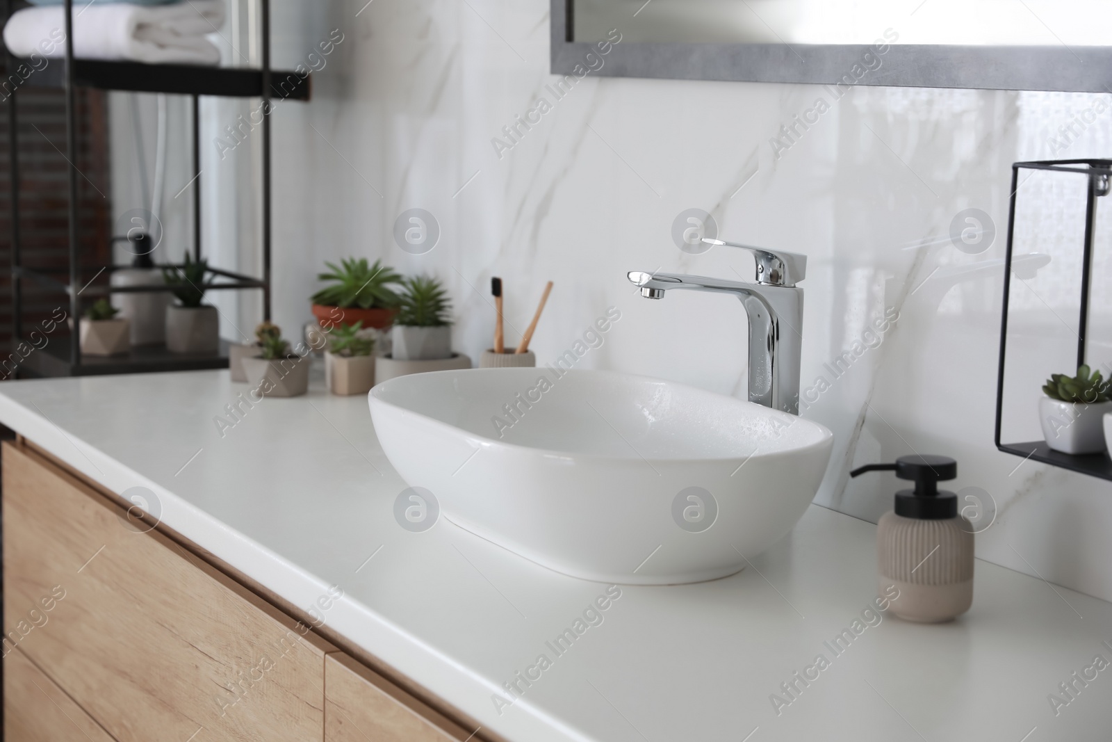 Photo of Stylish vessel sink on bathroom counter. Interior design