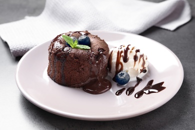 Photo of Plate of delicious fresh fondant with hot chocolate and blueberries on table. Lava cake recipe