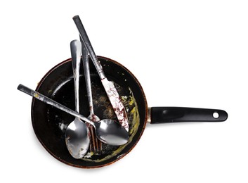 Dirty frying pan and cutlery on white background, top view