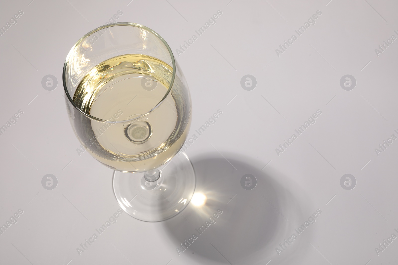 Photo of Tasty aromatic wine in glass isolated on white, above view