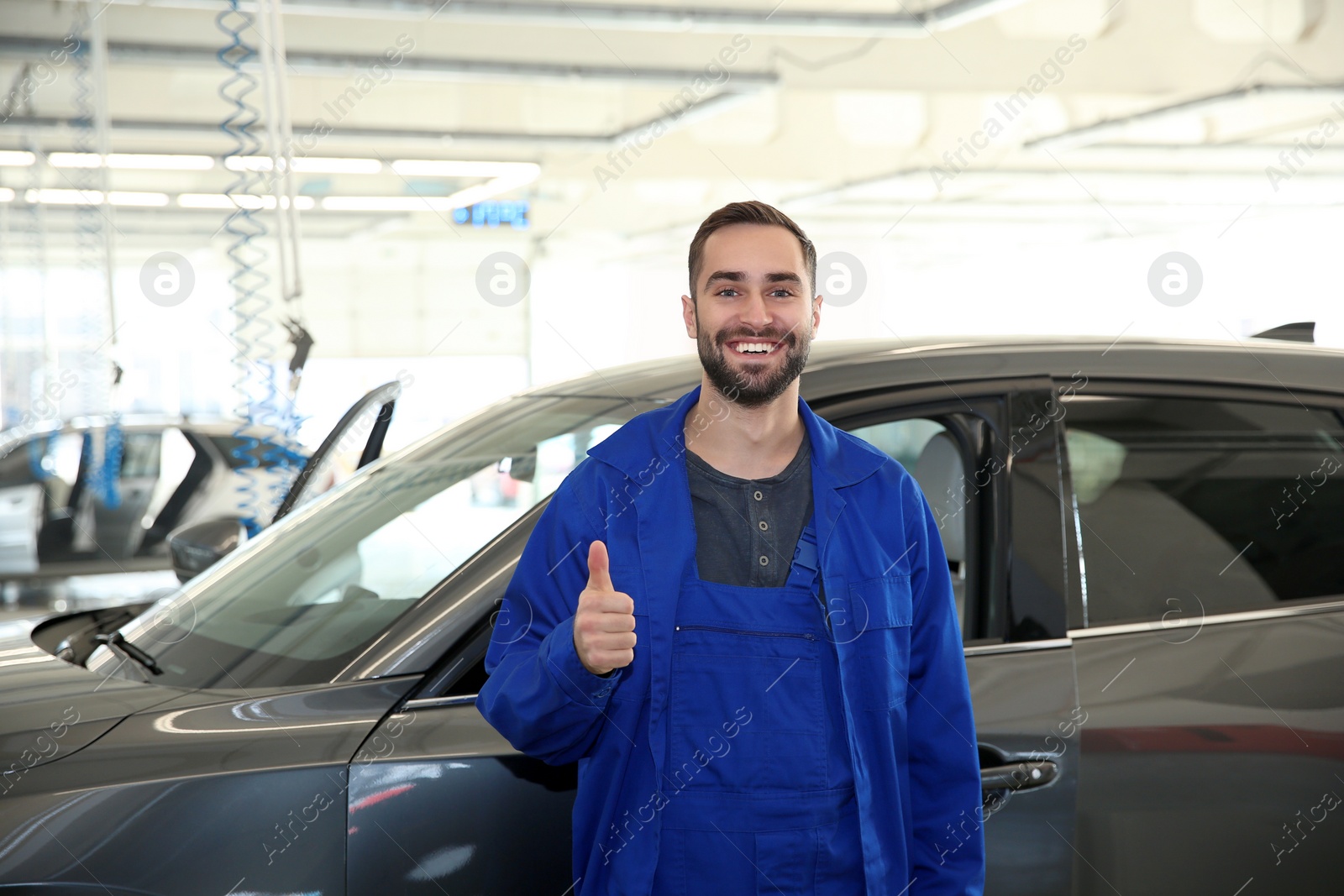 Photo of Portrait of worker standing near automobile at car wash