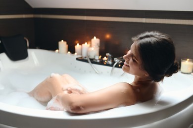 Happy beautiful woman taking bubble bath. Romantic atmosphere