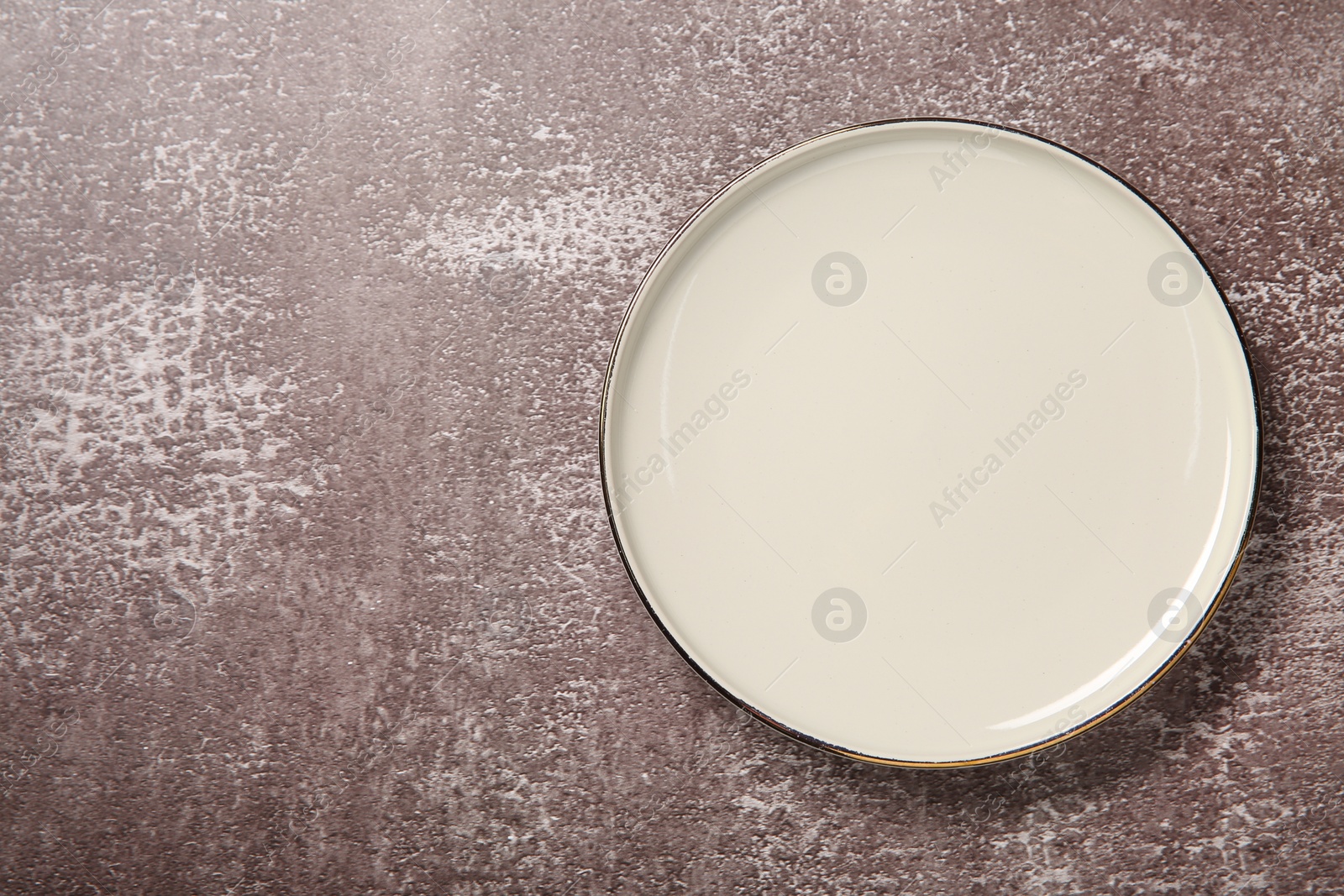 Photo of One white ceramic plate on textured table, top view. Space for text