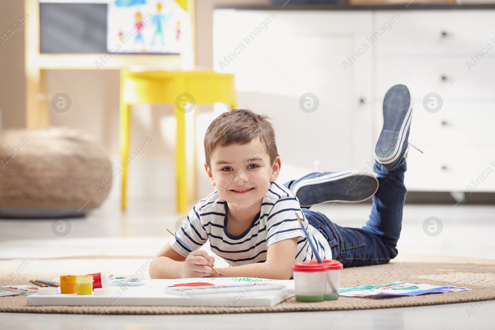 Photo of Little child painting on floor at home