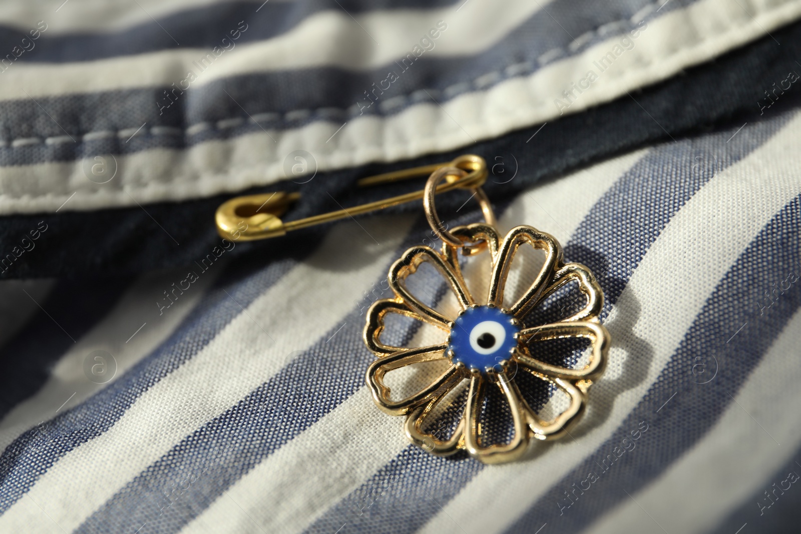 Photo of Evil eye safety pin on clothing, closeup