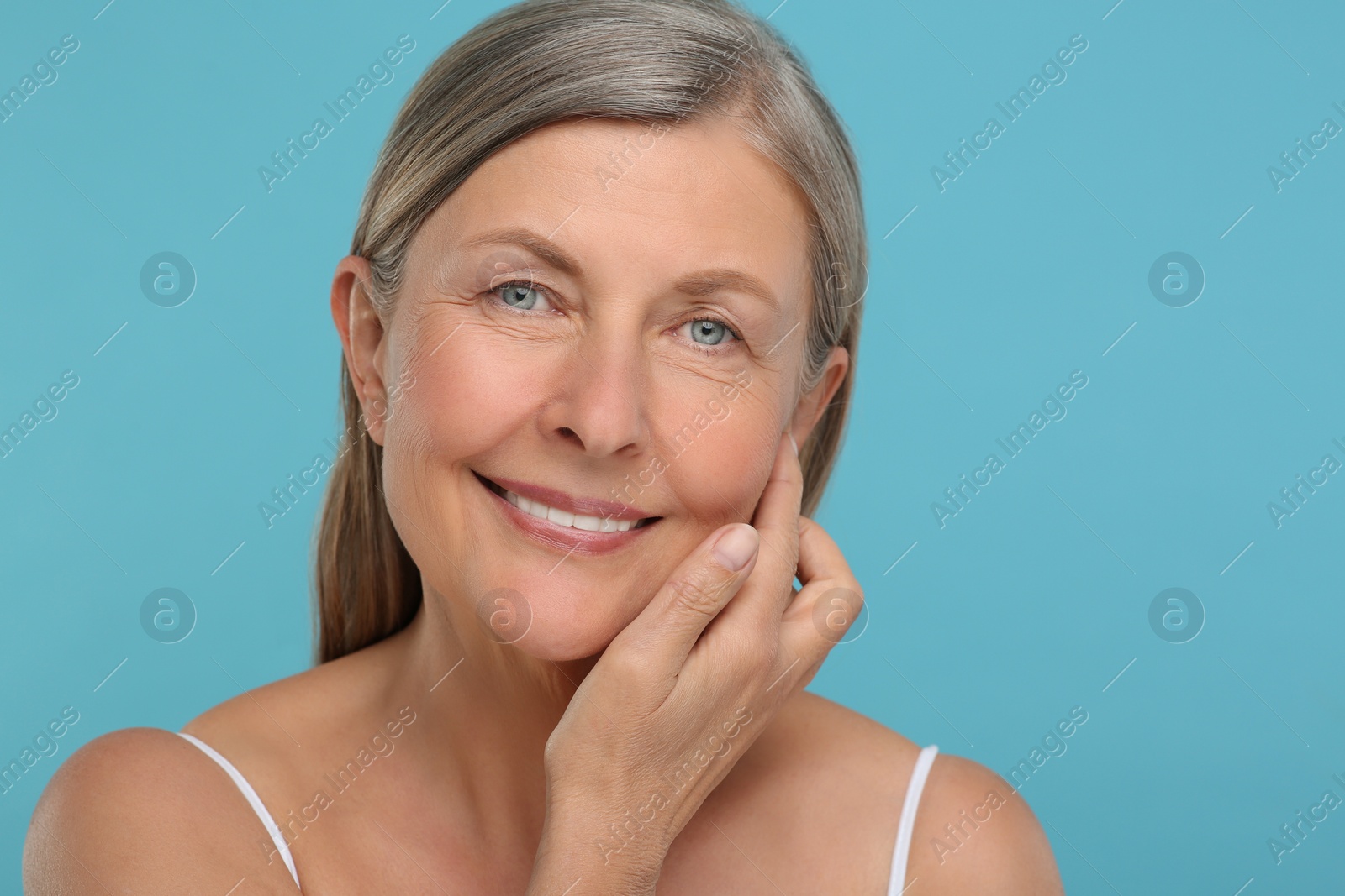 Photo of Portrait of senior woman with aging skin on light blue background. Rejuvenation treatment