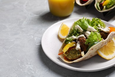 Photo of Delicious fresh vegan taco served on light grey marble table, space for text