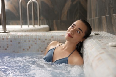 Photo of Beautiful woman relaxing in spa swimming pool, space for text