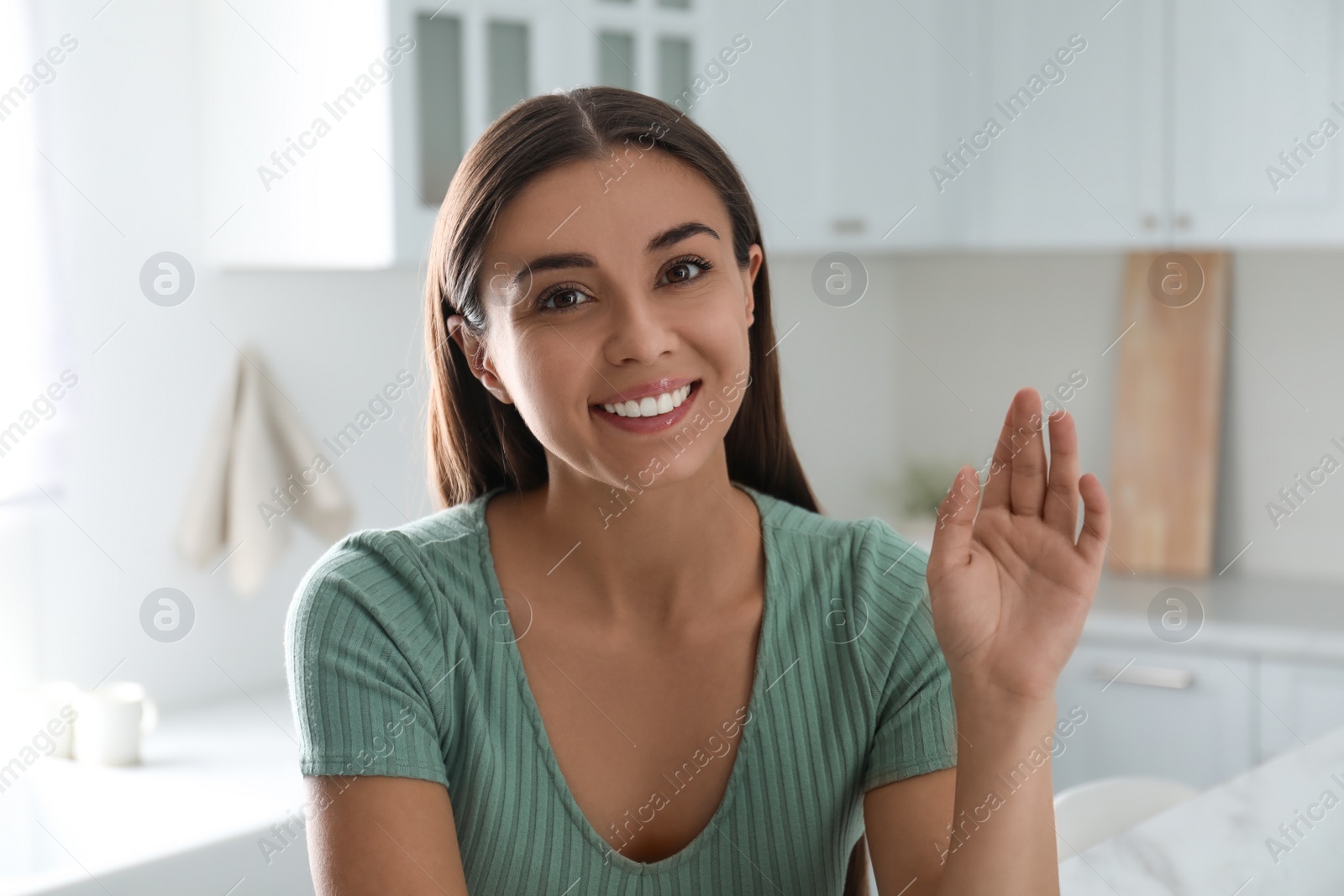 Photo of Young woman talking to his coworkers through video conference indoors, view from webcam