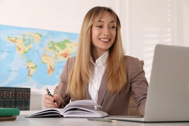 Photo of Happy manager working at desk in travel agency