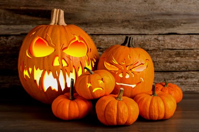 Image of Spooky jack o`lanterns on wooden table. Halloween decor