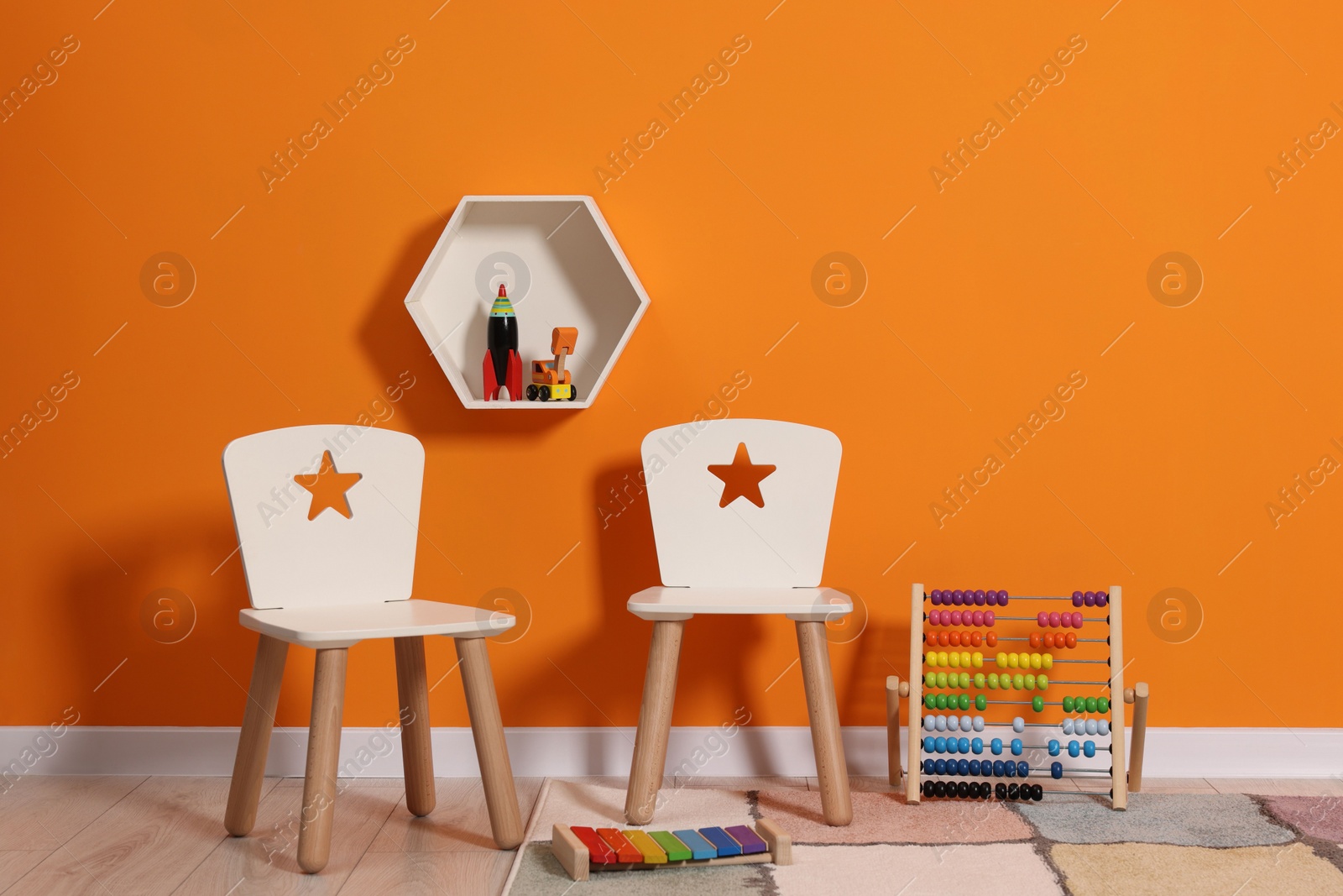 Photo of Beautiful children's room with bright orange wall and furniture. Interior design