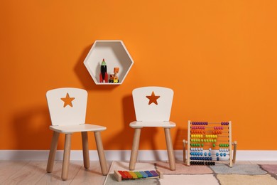Photo of Beautiful children's room with bright orange wall and furniture. Interior design