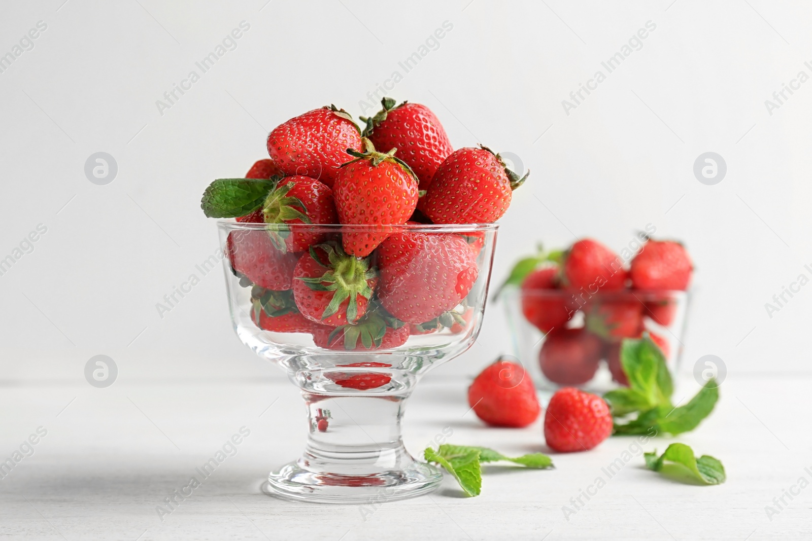 Photo of Dessert bowl with ripe red strawberries on table