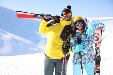 Photo of Young couple with skis on hill. Winter vacation