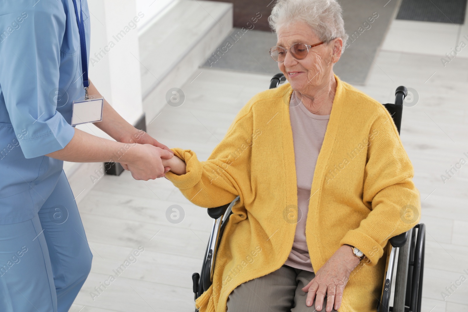 Photo of Nurse assisting senior woman in wheelchair at hospital