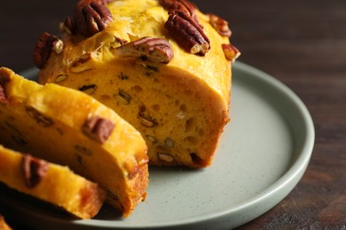 Photo of Delicious pumpkin bread with pecan nuts on wooden table, closeup