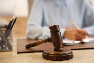 Notary with clipboard writing notes at workplace in office, focus on mallet