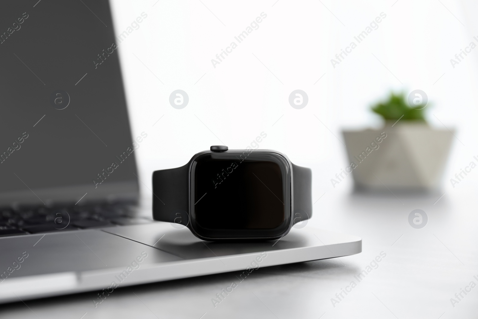 Stylish smart watch and laptop on grey table, closeup Photo of Stylish smart watch and laptop on grey table, closeup