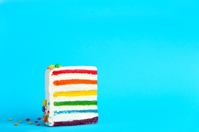 Photo of Slice of delicious rainbow cake on color background