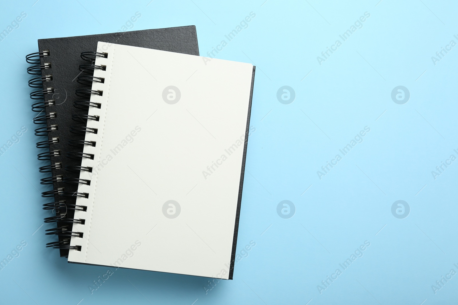 Photo of Notebooks on black background, top view. Space for text