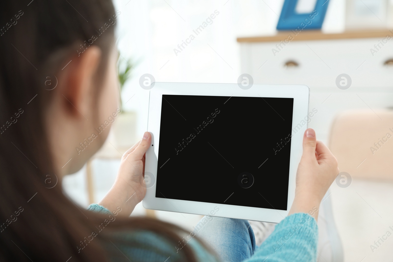 Photo of Little girl using video chat on tablet at home. Space for text