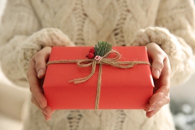 Photo of Woman holding red Christmas gift box, closeup