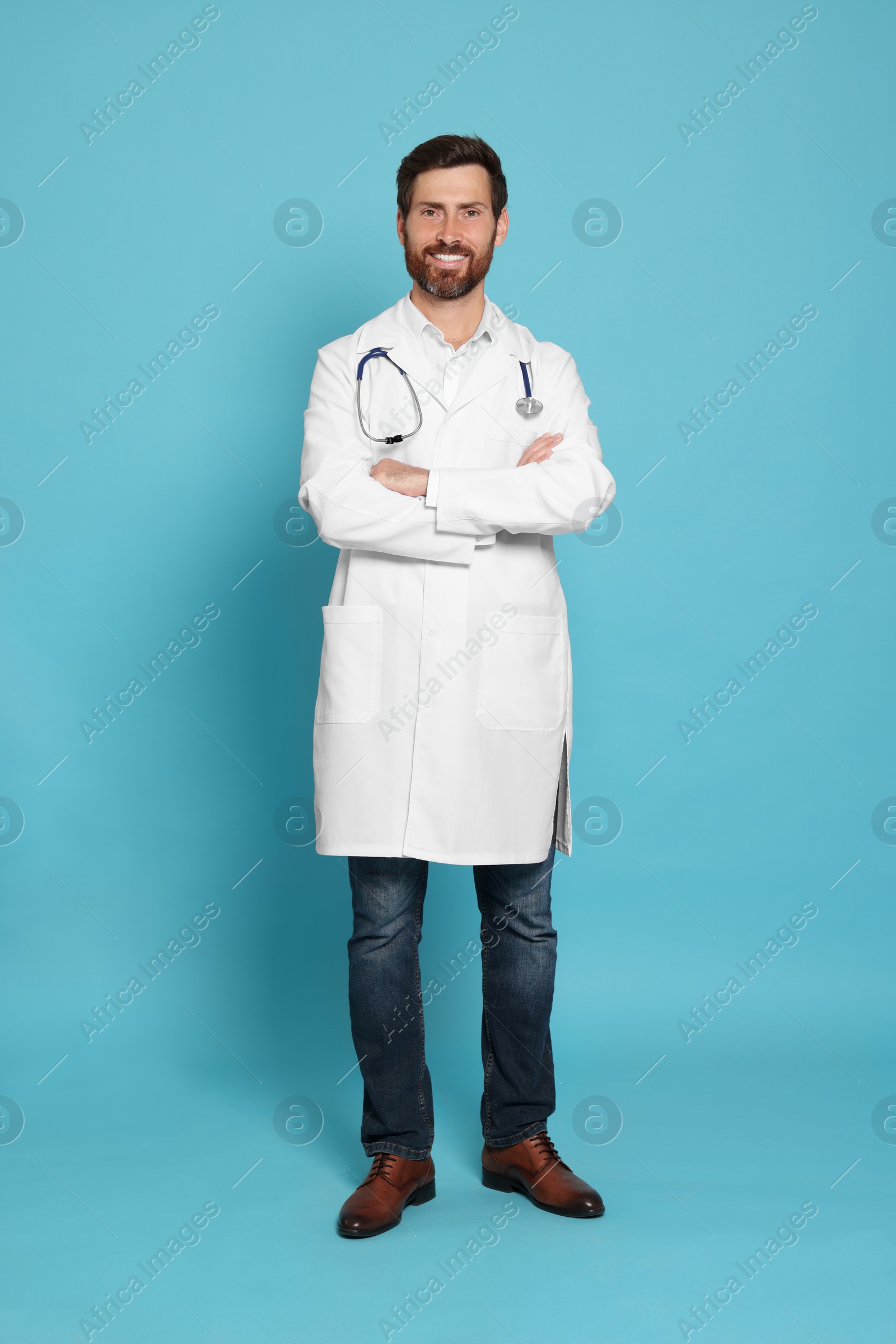 Photo of Full length portrait of doctor with stethoscope on light blue background