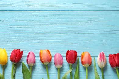 Photo of Beautiful tulips and space for text on wooden background, top view. Spring flowers