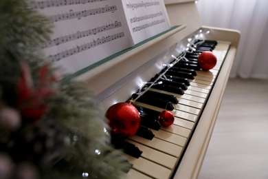 White grand piano with festive decor indoors, closeup. Christmas music