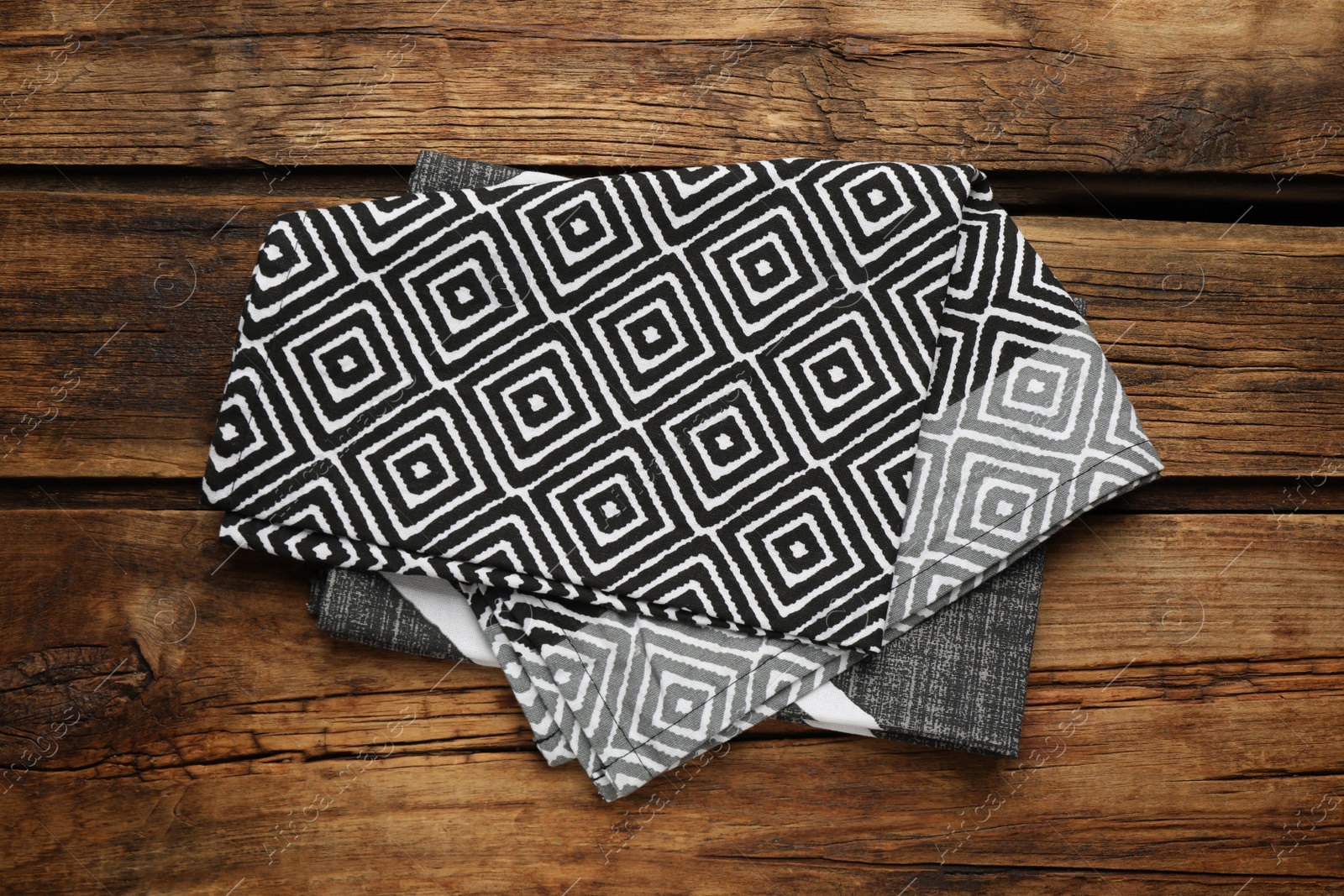 Photo of Beautiful kitchen towels on wooden table, top view