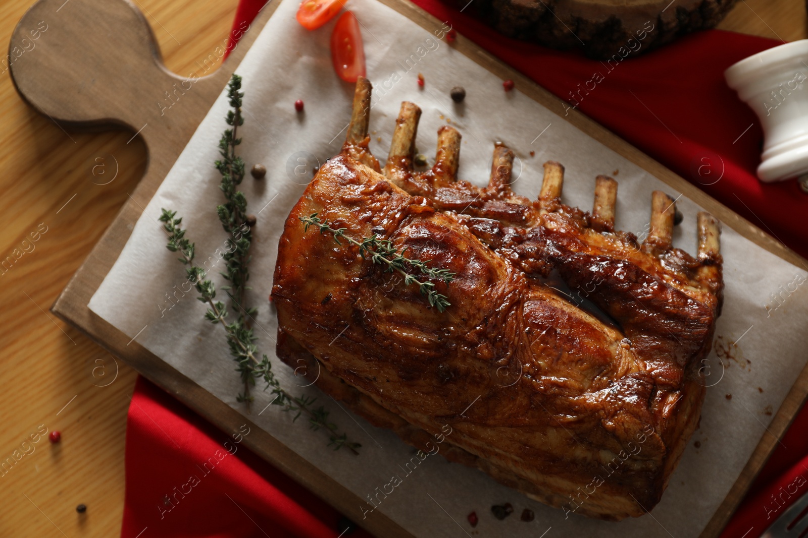 Photo of Delicious roasted ribs served on wooden table, flat lay