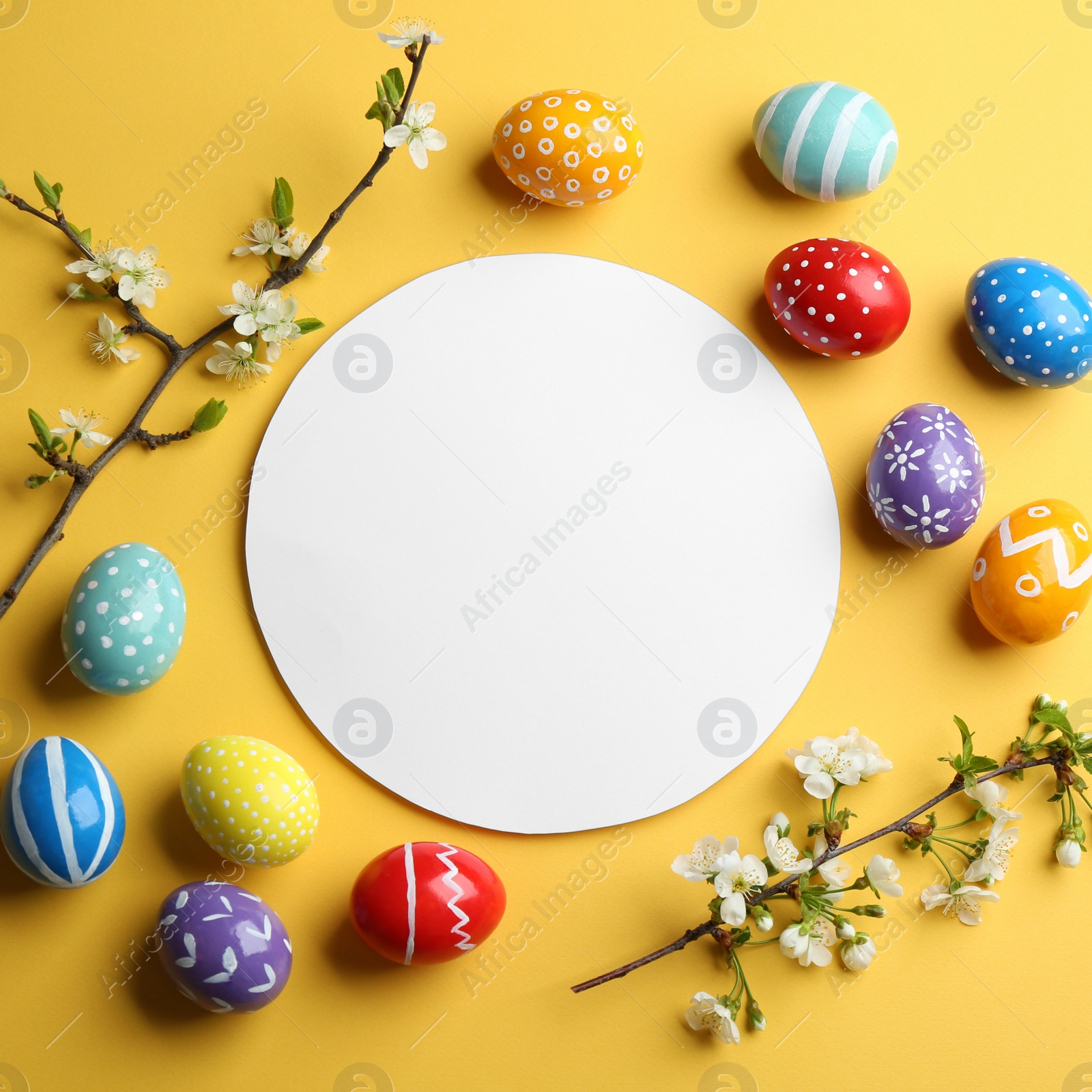 Photo of Flat lay composition with painted Easter eggs and blank card on color background, space for text