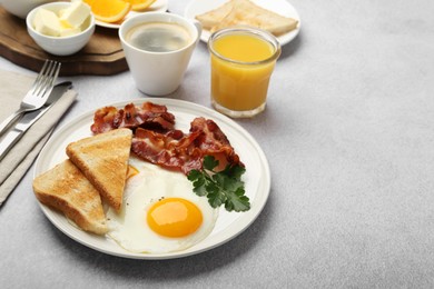 Photo of Delicious breakfast with sunny side up egg served on light table. Space for text