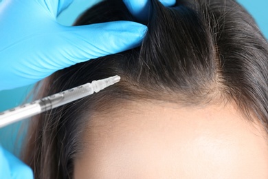 Photo of Young woman with hair loss problem receiving injection, closeup