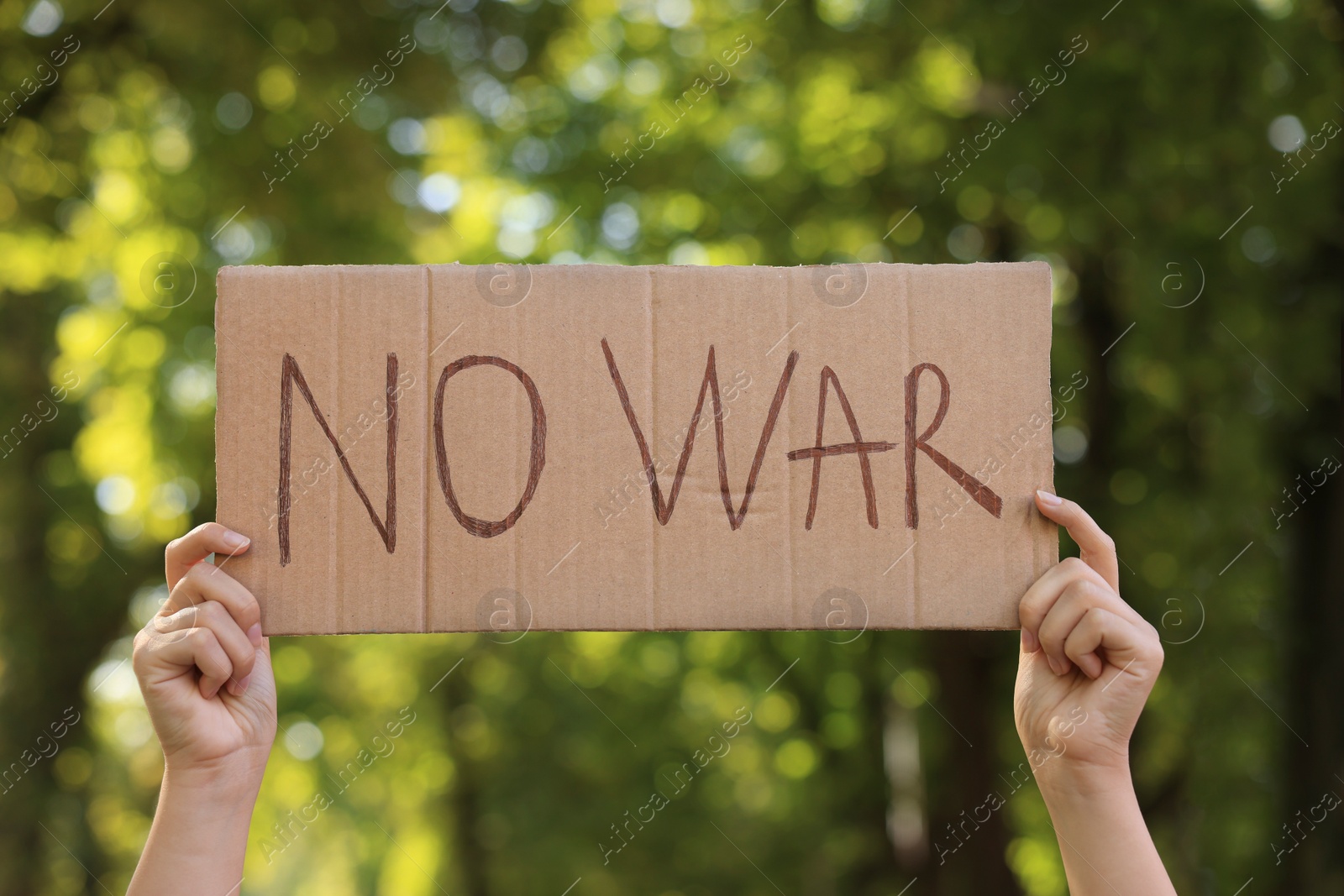 Photo of Woman holding poster with words No War in park, closeup