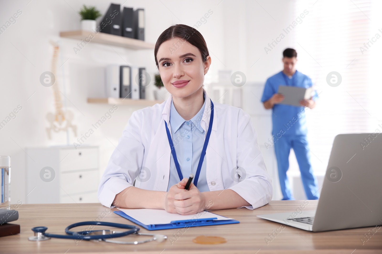 Photo of Portrait of female doctor at table in modern clinic