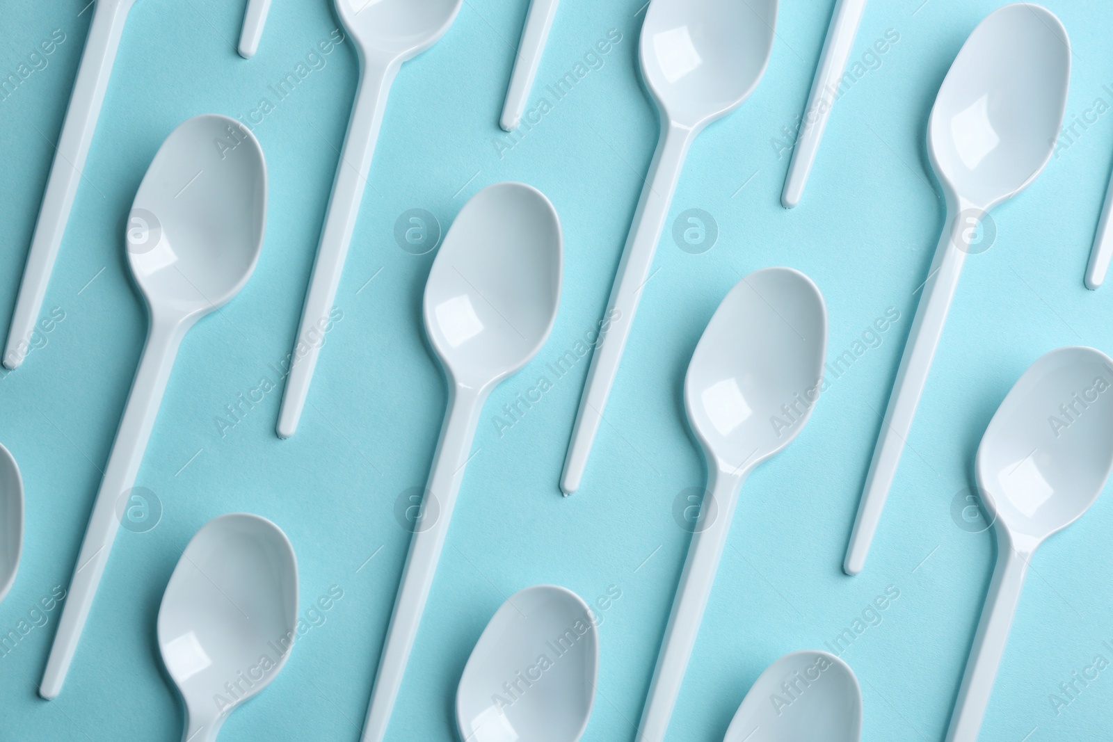 Photo of Flat lay composition with plastic spoons on color background. Table setting