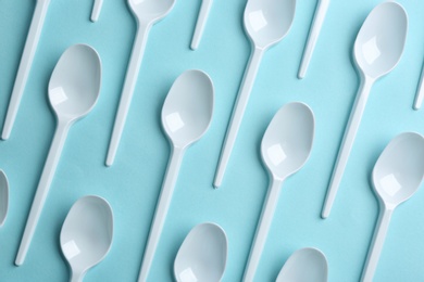 Flat lay composition with plastic spoons on color background. Table setting