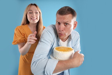 Photo of Greedy man hiding tasty cake from woman on turquoise background