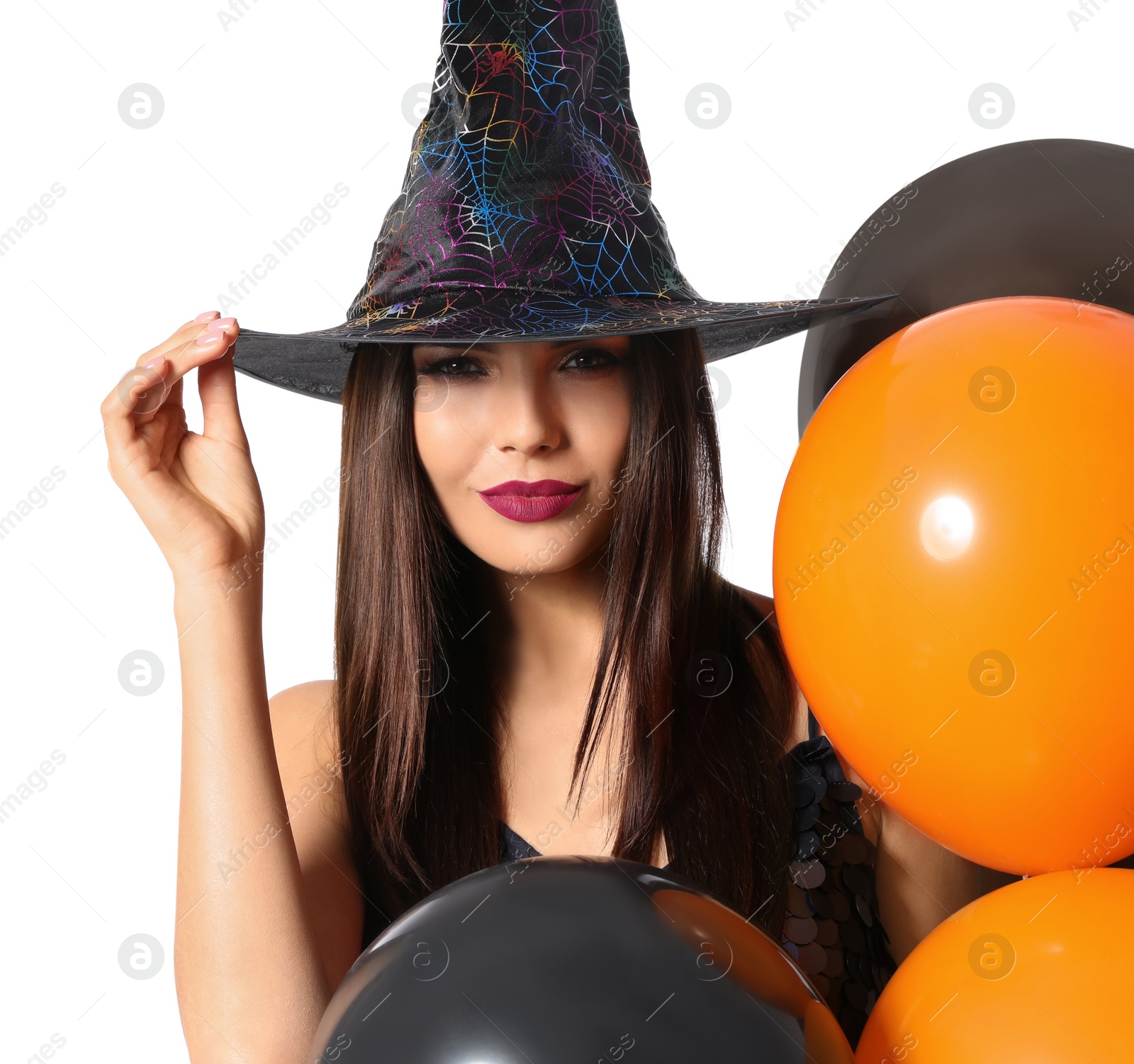 Photo of Beautiful woman wearing witch costume with balloons for Halloween party on white background