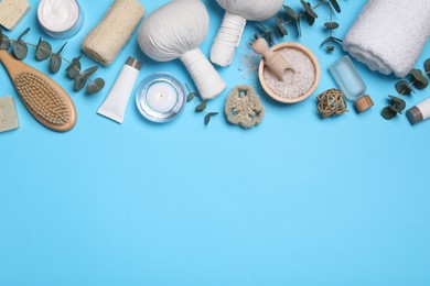 Flat lay composition with spa products and eucalyptus branches on light blue background. Space for text