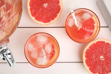 Delicious refreshing lemonade with grapefruit slices on white wooden table, flat lay