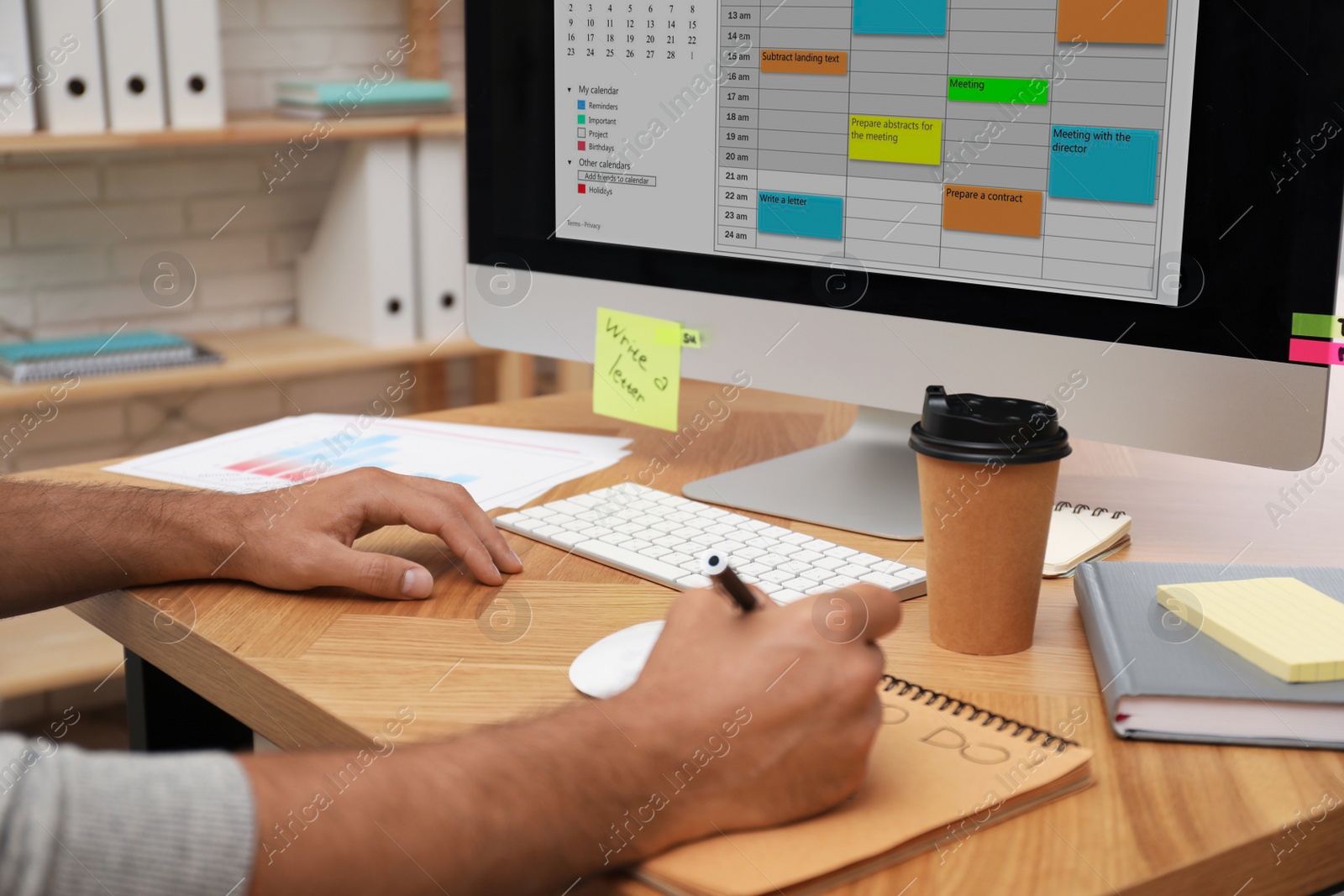 Photo of Man planning his schedule with calendar app on computer in office, closeup