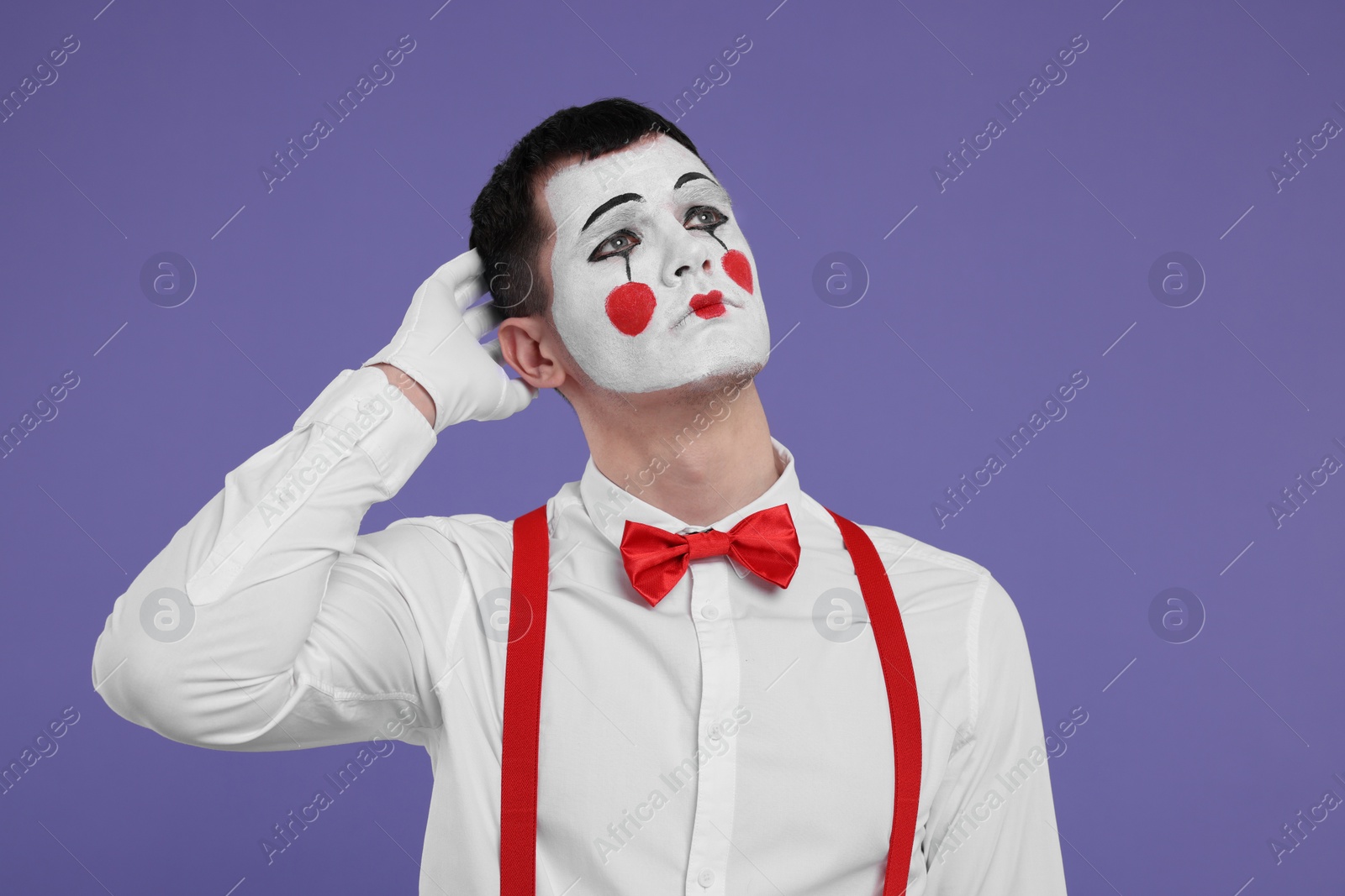 Photo of Portrait of mime artist on purple background