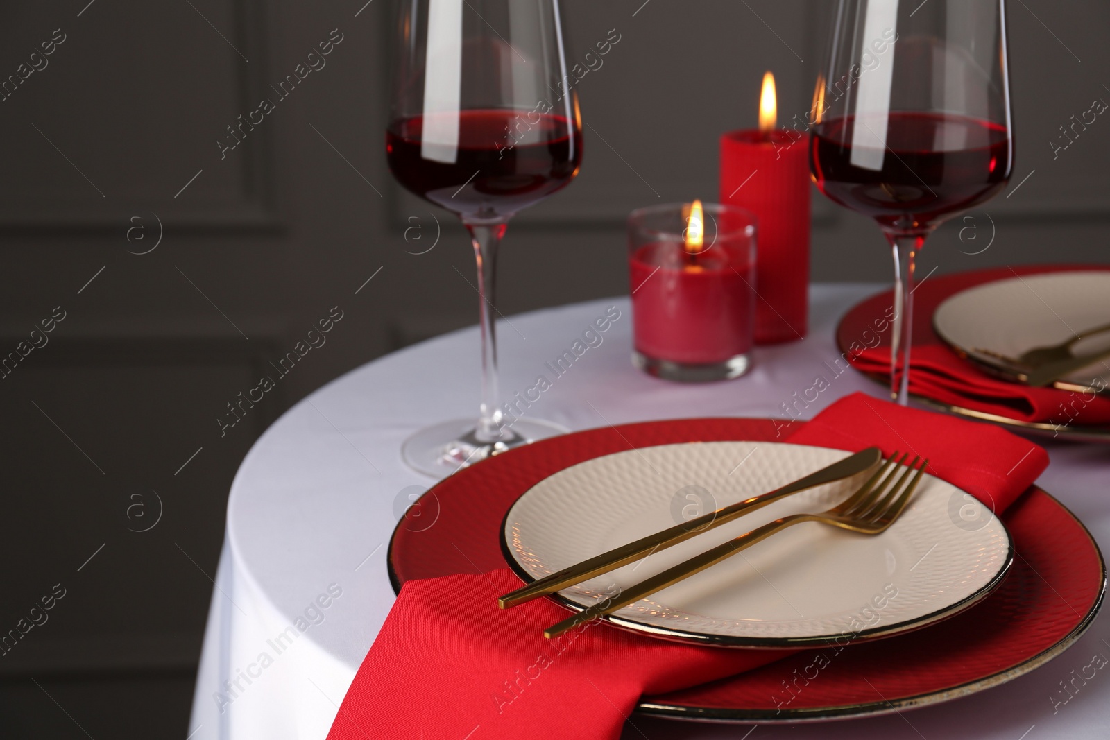 Photo of Place setting with candles for romantic dinner on white table, closeup. Space for text