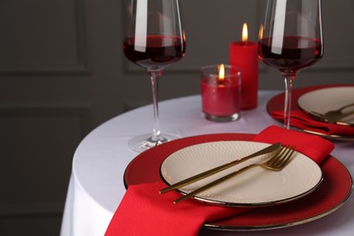 Photo of Place setting with candles for romantic dinner on white table, closeup. Space for text