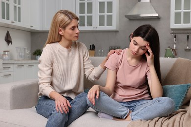 Mother consoling her upset daughter at home. Teenager problems